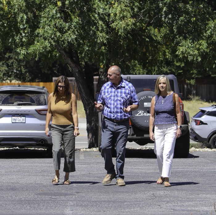 Mike Avila walking through a parking lot with two women